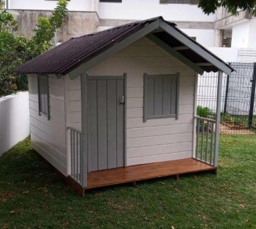 Casinha infantil de madeira térrea pintada, com varandinha e telhado ecológico