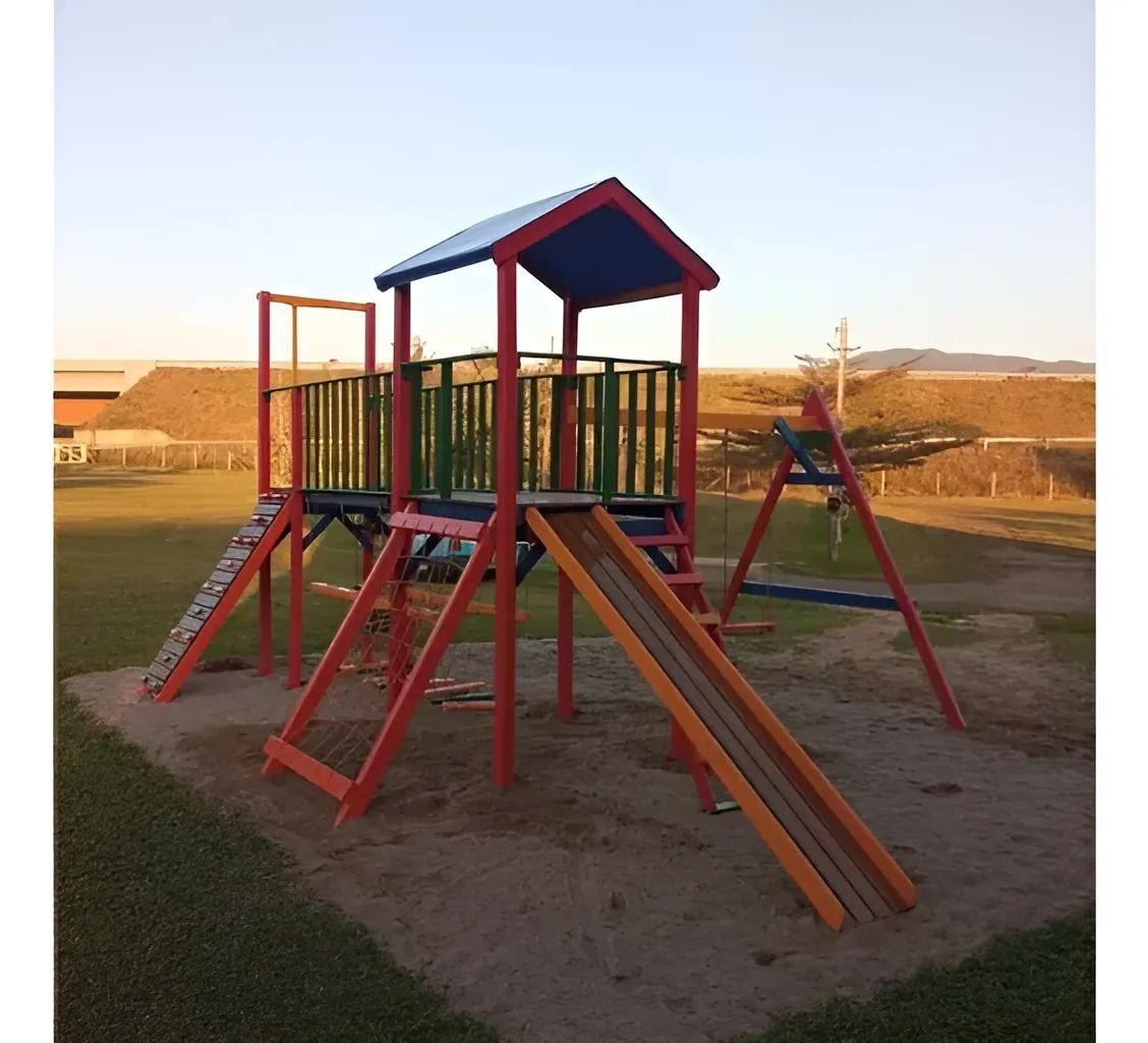 Parque infantil de madeira com torre coberta, ponte com arvorismo, escorregador reto e balanços
